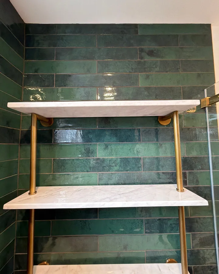 After: stone and brass shelves in the shower