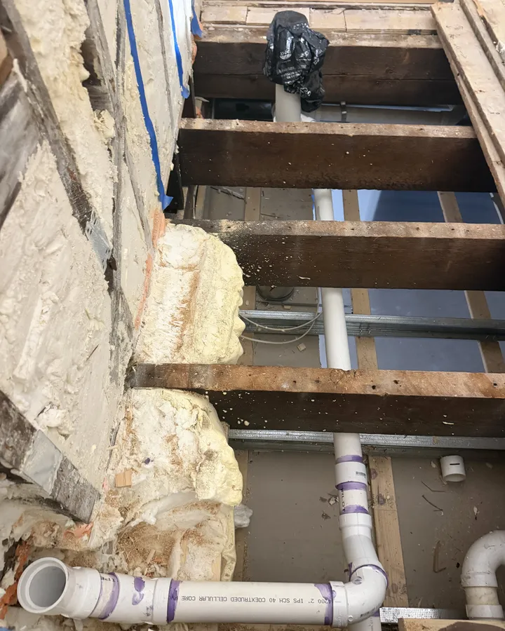 During: new drain lines run through the floor framing
