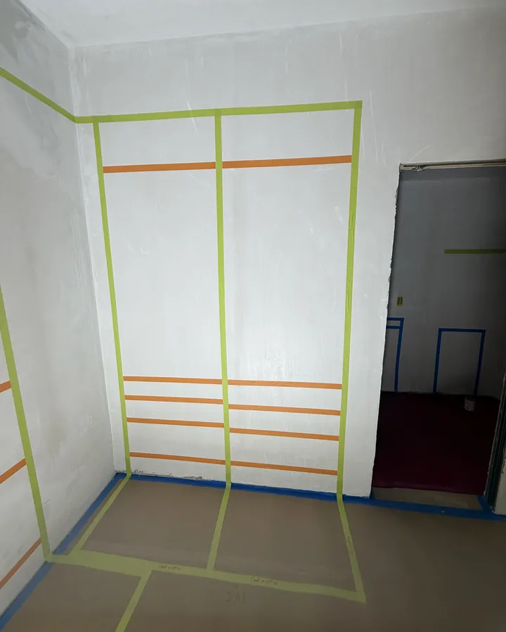 During: the closet system laid out in tape on the walls