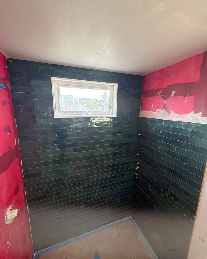 During: green tile going up around the new shower window